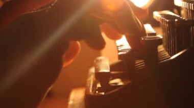 Eski tip antika daktiloda yazan adamın yakın çekim görüntüsü; arka ışıklandırma; haber, medya veya iletişim konsepti