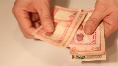 Adamın elleri Nepal banknotlarını sayıyor. Nepal Ulusal Para Birimi (NPR)