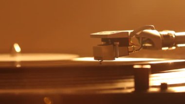 Plak plağındaki pikap iğnesini kapat. Turntable vinil çalıyor. Dönen siyah plağa iğne yap. Arkaplan