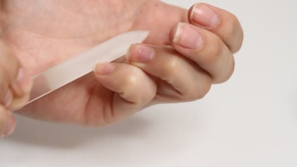 Femme fait la manucure par elle-même sur fond blanc. Service de manucure auto-fabriqué 