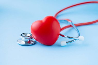 Steteskop ve kırmızı kalp mavi zemin üzerine. 