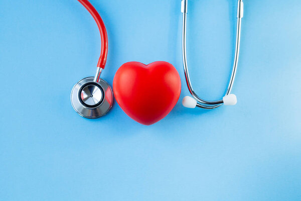 Stethoscope and red heart on blue background. 