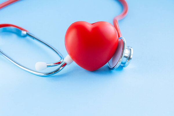 Stethoscope and red heart on blue background. 