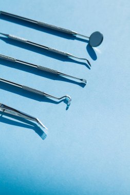 Mavi arka planda dişçi araçları: Diş sağlığı ve diş sağlığı