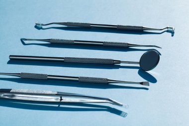 Mavi arka planda dişçi araçları: Diş sağlığı ve diş sağlığı 
