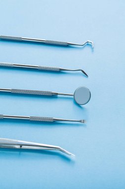 Mavi arka planda dişçi araçları: Diş sağlığı ve diş sağlığı 