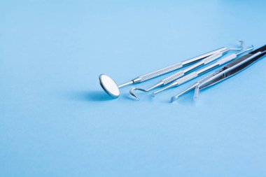 Mavi arka planda dişçi araçları: Diş sağlığı ve diş sağlığı 