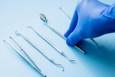 Mavi arka planda dişçi araçları: Diş sağlığı ve diş sağlığı 