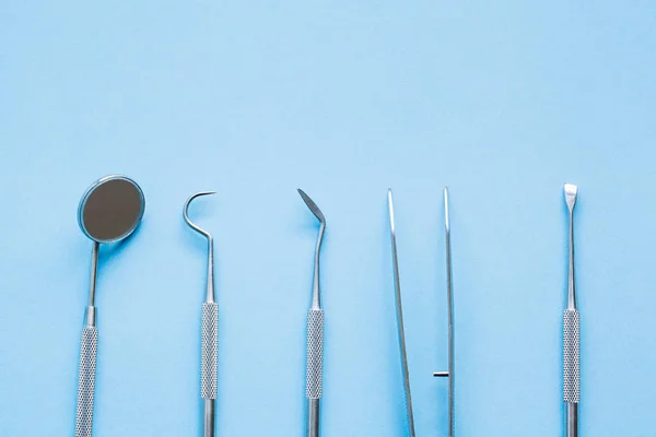 Outils de dentiste sur fond bleu : Hygiène dentaire et santé — Photo