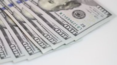 Yüz dolar faturaları bir masaya dönüyor. Yakın çekim. Döndürme kağıt para yakın çekim. Arka plan ile para Amerikan yüz dolar faturaları