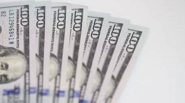 Yüz dolar faturaları bir masaya dönüyor. Yakın çekim. Döndürme kağıt para yakın çekim. Arka plan ile para Amerikan yüz dolar faturaları