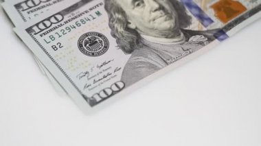 Yüz dolar faturaları bir masaya dönüyor. Yakın çekim. Döndürme kağıt para yakın çekim. Arka plan ile para Amerikan yüz dolar faturaları