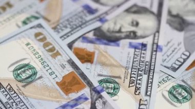 Yüz dolar faturaları bir masaya dönüyor. Yakın çekim. Döndürme kağıt para yakın çekim. Arka plan ile para Amerikan yüz dolar faturaları