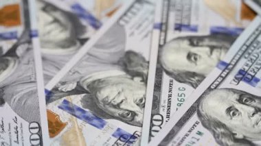 Yüz dolar faturaları bir masaya dönüyor. Yakın çekim. Döndürme kağıt para yakın çekim. Arka plan ile para Amerikan yüz dolar faturaları