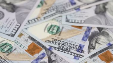 Yüz dolar faturaları bir masaya dönüyor. Yakın çekim. Döndürme kağıt para yakın çekim. Arka plan ile para Amerikan yüz dolar faturaları