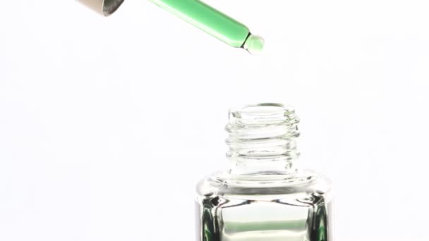 緑の油滴の閉じ込めは 白い背景に ピペットから落下します ボトルに油を滴下ドロッパー 美容とヘルスケア マクロショット — ストック動画