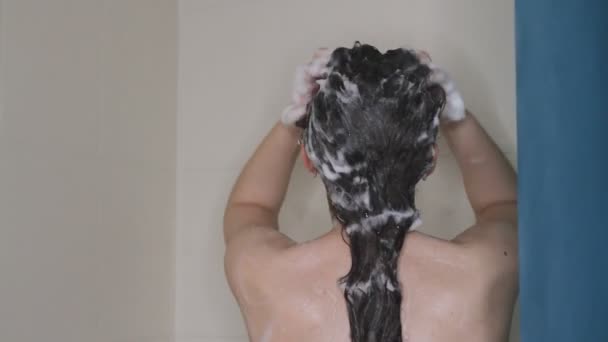 Zbliżenie Młodej Białej Kobiety Myje Długie Ciemne Włosy Szamponem Pod — Wideo stockowe