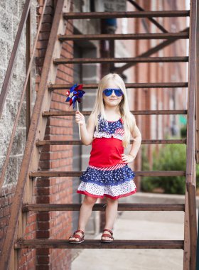 Güneş gözlüğü ve fırıldak ile poz şık küçük kız