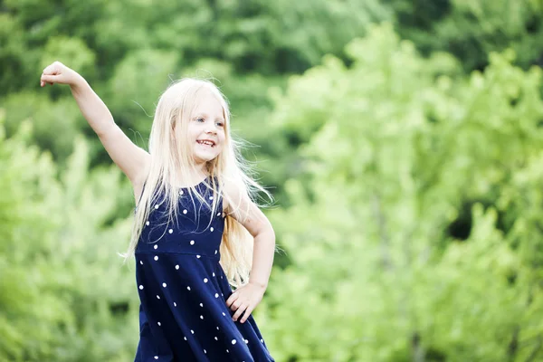 Ritratto di bambina felice in posa in abito blu punteggiato — Foto Stock