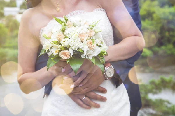 Close-up of newlywed husband embracing wife