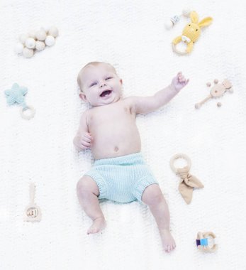 Heyecanlı küçük bebek çıngıraklı beşikte yatıyor