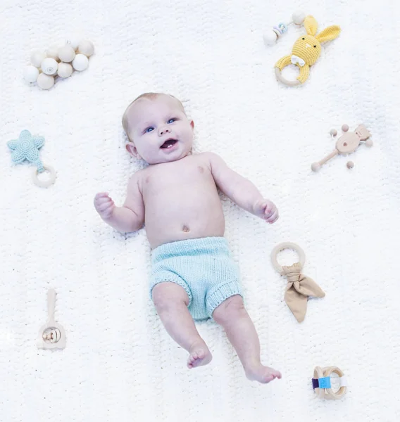 Sonriente bebé acostado en bragas azules en la cama — Foto de Stock