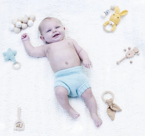 Retrato de bebé lindo feliz acostado con juguetes — Foto de Stock
