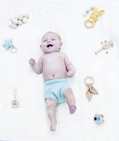 Retrato de niño alegre acostado con sonajeros — Foto de Stock