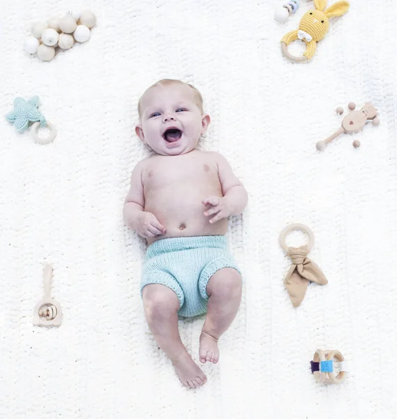 Neşeli küçük bebek çıngıraklı beşikte yatıyor