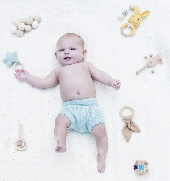 Pequeño bebé sonriente usando pañal azul con sonajeros — Foto de Stock