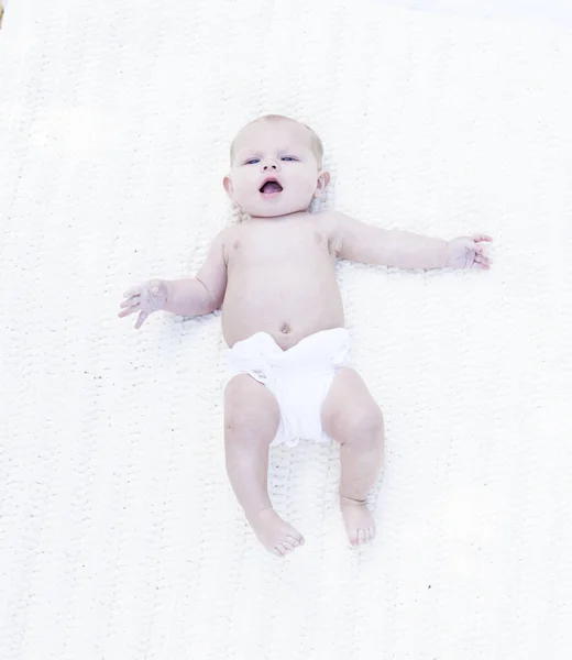 Retrato de bebé lindo acostado en la cama con la boca abierta — Foto de Stock