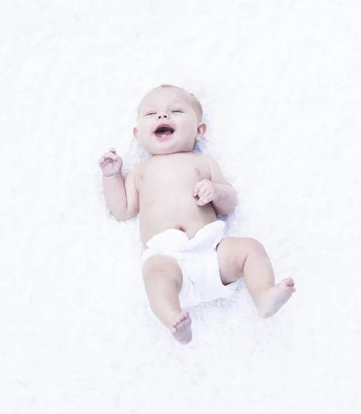 Retrato de niño alegre en pañal acostado y riendo — Foto de Stock