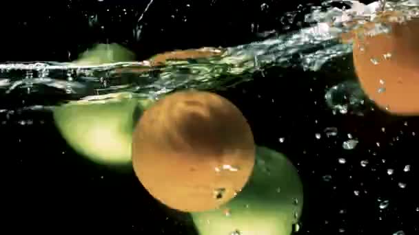 Manzanas Verdes Frescas Naranjas Caen Agua Con Salpicaduras Fondo Negro — Vídeos de Stock