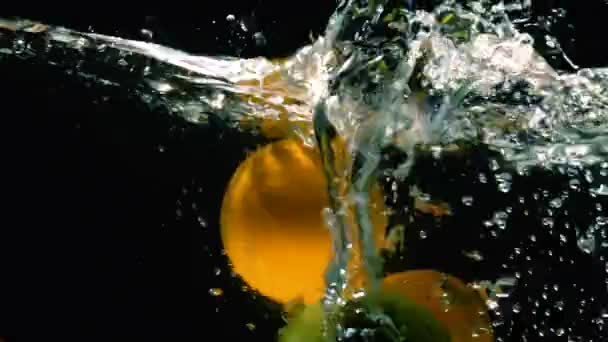 Manzanas Verdes Frescas Naranjas Caen Agua Con Salpicaduras Sobre Fondo — Vídeos de Stock