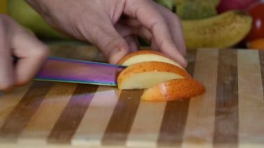 Kesme elma kesme tahtası üzerinde bir adamdır