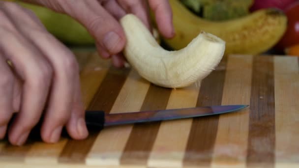 Uomo Sta Tagliando Banana Sul Tagliere — Video Stock