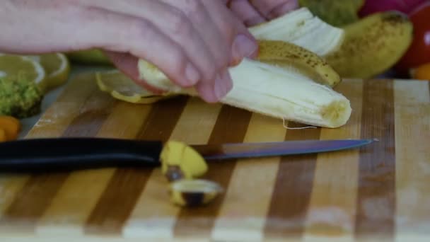 男はスローモーションでまな板に皮をむいたバナナを入れてください — ストック動画