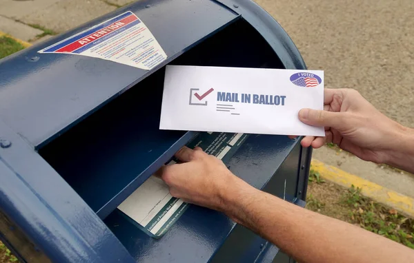 一个男人把缺席的选票放在信箱里 — 图库照片