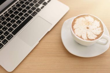 Kahve Kupası en iyi manzaralı ahşap masa üstünde Laptop