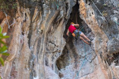 Genç adam atletizm için pratik bir uçurum zorlu bir iz üzerinde tırmanma sırasında ararken