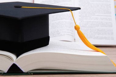 Siyah kitap üzerine yerleştirilen mezun Püskül kap.