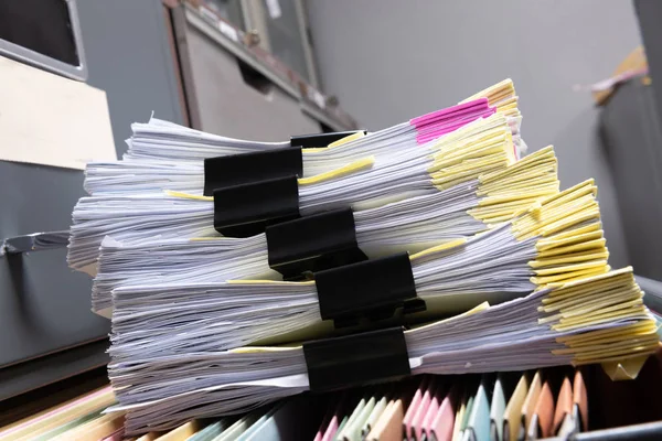 Colorful business documents are placed in a filing cabinet in the office.