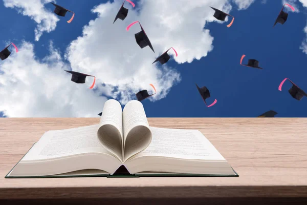Ανοίξτε Βιβλίο Στο Ξύλινο Τραπέζι Σκηνικό Είναι Ένα Καπέλο Αποφοίτησης — Φωτογραφία Αρχείου
