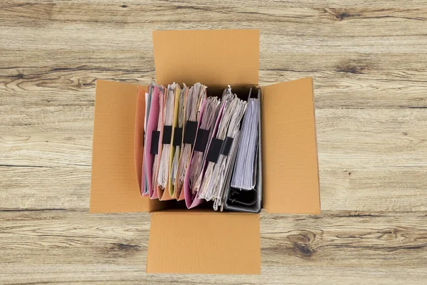 The documents and files are placed in a brown box on the table.