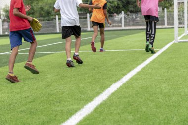 Çocuklar futbol idmanı için yeşil çim oynamak.