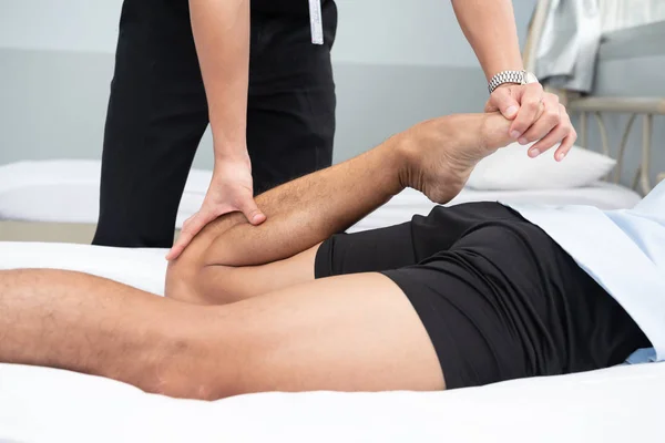 Fisioterapisti Usano Maniglie Nella Gamba Del Paziente Sdraiarsi Sul Letto — Foto Stock