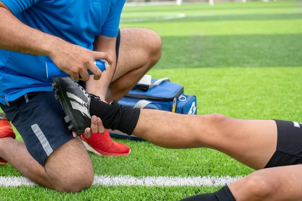 Mavi bir gömlek, siyah pantolon içinde çim yarış sırasında yaralı giyen futbolcu.