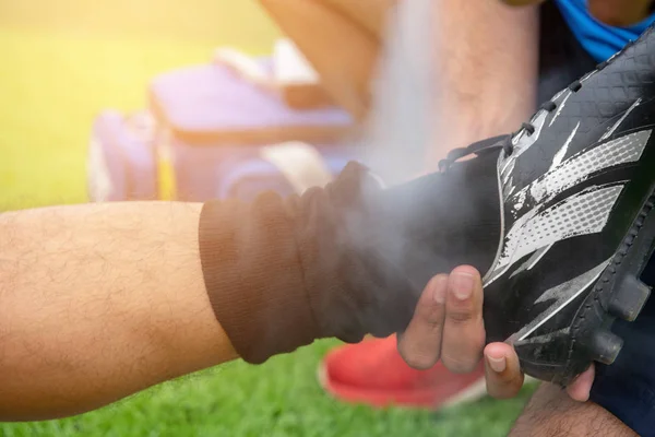 Mavi bir gömlek, siyah pantolon içinde çim yarış sırasında yaralı giyen futbolcu.