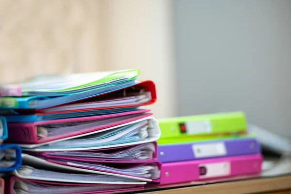 Ofis masasının üzerinde renkli dosyalar var