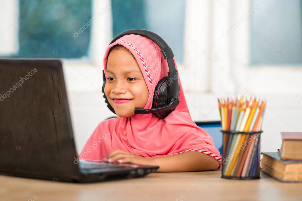 Muslim girls studying online at home To reduce social distance and prevent communicable diseases